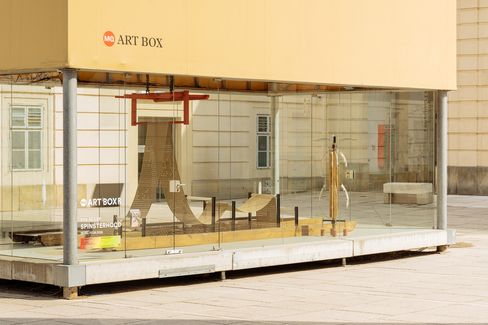 Angled view of the MQ Art Box showing the exhibition inside, consisting of wooden structures and suspended elements.