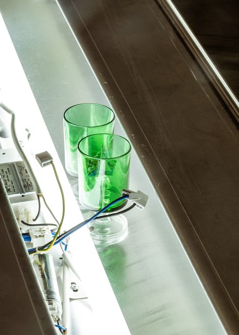 Detail showing two green glasses and exposed electrical components within the installation.