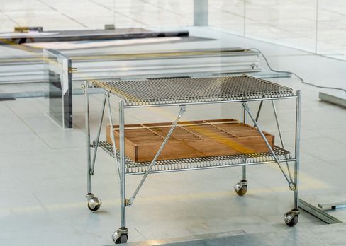 Close-up of a metal trolley with wire shelf and wooden tray as part of the installation in the MQ Art Box.