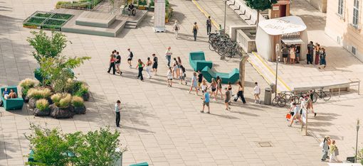 MQ Haupthof gefüllt mir Menschen an einem sonnigen Tag.