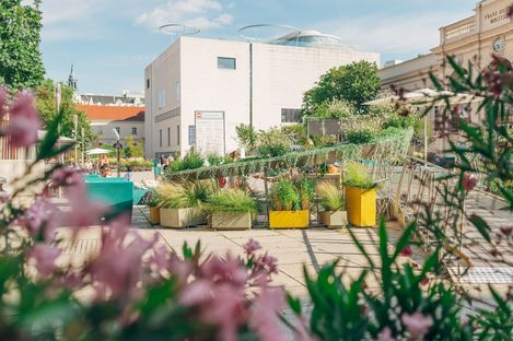 Blick auf das Leopold Museum mit der MQ Sommerbühne davor, umgeben von Pflanzen und Sitzgelegenheiten im MuseumsQuartier Wien