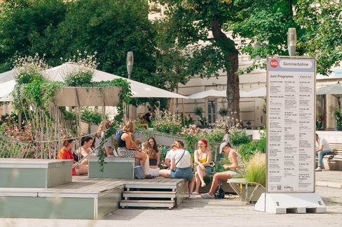 Viele junge Leute sitzen auf der MQ-Sommerbühne und unterhalten sich.