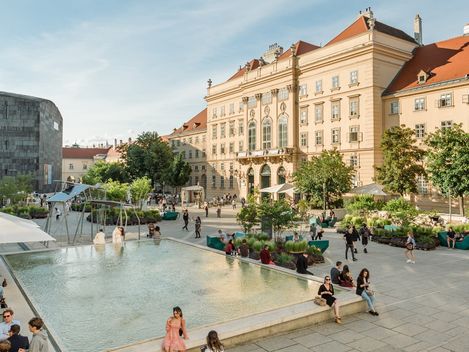 Belebter MQ Haupthof and einem sonnigen Tag.