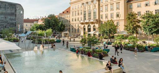 Bustling MQ main courtyard on a sunny day.