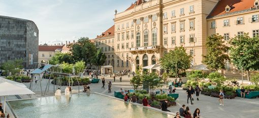 Belebter MQ Haupthof and einem sonnigen Tag.