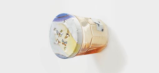 A sculpture of an oversized honey jar by Magali Reus, installed horizontally on the wall.