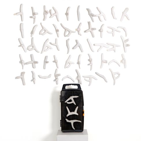 Black rectangular box with white abstract figures in various poses arranged above and on it.