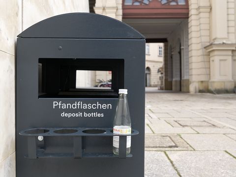 schwarzer Pfandbehälter an der Seite eines Mistkübels im MQ