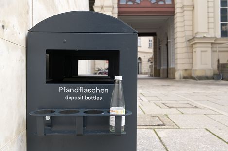Black deposit container on the side of a trash can in the MQ