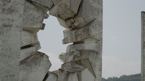 Nahaufnahme eines grob behauenen, zackigen Steindenkmals mit unregelmäßiger Öffnung in der Mitte.