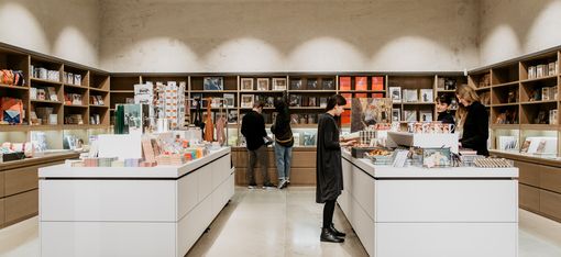View into the Leopold Museum shop with central display tables and shelves filled with art books, design objects, and souvenirs.
