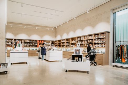 Wide view through the Leopold Museum shop showing visitors, display tables, and a selection of books, prints, and merchandise.