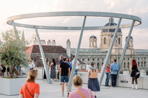 Menschen auf der Dachterrasse der MQ Libelle an einem sonnigen Tag.