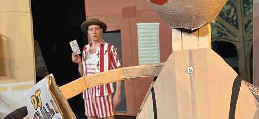 A young man is standing on the beach, slightly behind a woman. She isn’t a real person.
