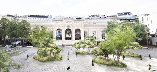 Visualisierung Staudeninseln im MQ Haupthof.
Das historische Gebäude des Tanzquartier mit seinen Bögen und Säulen bildet die Kulisse für den weitläufigen MQ Hauptplatz , der von Bäumen gesäumt ist und auf dem Menschen flanieren. Die Szene ist hell und ruhig.