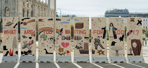 Pillars displaying colored-pencil drawings on both sides stand against an urban backdrop.