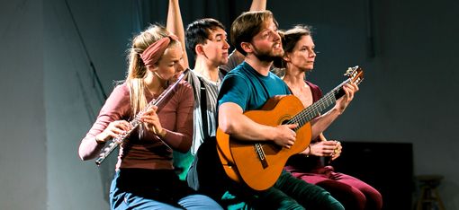 Das Bild zeigt eine Gruppe von vier Personen, zwei Männer und zwei Frauen, die auf einer Bank sitzen und Musikinstrumente spielen. Die beiden Männer spielen Gitarre, während die Frauen Flöte spielen. Sie genießen ihre gemeinsame Zeit, möglicherweise geben sie ein Konzert oder spielen einfach nur zum Spaß.
Die Bank, auf der sie sitzen, befindet sich in der Mitte der Szene, und alle sitzen bequem darauf. Die Gitarren liegen in ihren Händen, und die Flöten werden von den Frauen gehalten. Die Szene vermittelt ein Gefühl der Kameradschaft und der gemeinsamen Leidenschaft für Musik unter den Gruppenmitgliedern.
