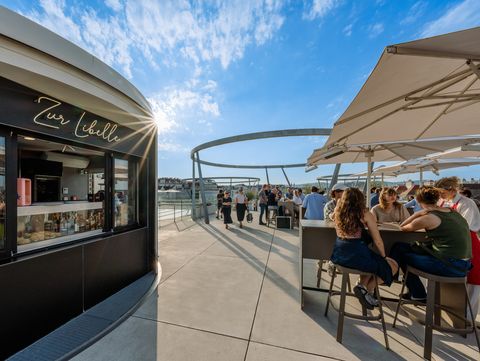 Bar Zur Libelle auf dem Dach des Leopold Museum im MuseumsQuartier Wien mit Gästen an Tischen unter Sonnenschirmen.