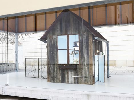 Detailansicht eines kleinen, verwitterten Holzhauses als Teil der Installation in der MQ Art Box.