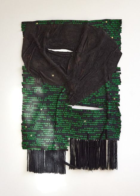 Textilkunstwerk mit schwarzem, zerknittertem Stoff auf grünem Hintergrund mit weißen Zahlen und schwarzen Fransen am unteren Rand