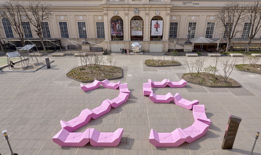 Im Haupthof des MuseumsQuartier Wien liegt eine große, aus vielen pinkfarbenen Sitzmodulen zusammengesetzte Zahl '25' auf dem Platz