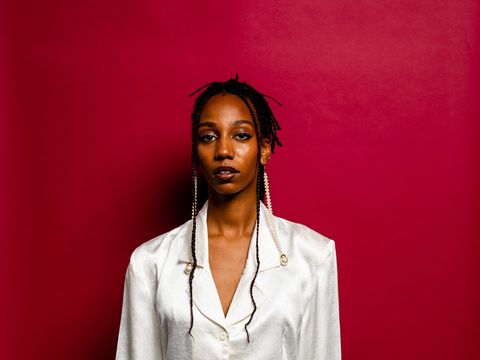 Portrait of a young woman in front of a red wall