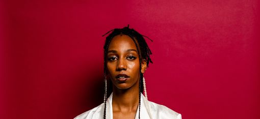 Portrait of a young woman in front of a red wall