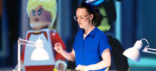 Laboratory scene: A person is handling plastic figures, which are shown enlarged in the background.