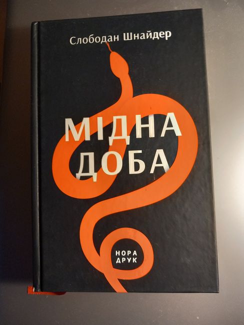 Black book with orange snake illustration and Cyrillic text on the cover.