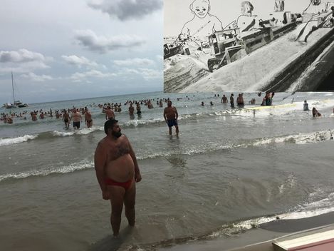Männer, die am Strand und im Wasser stehen.