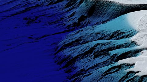 Landscape with snow-covered and shadowed mountain slopes under a blue sky