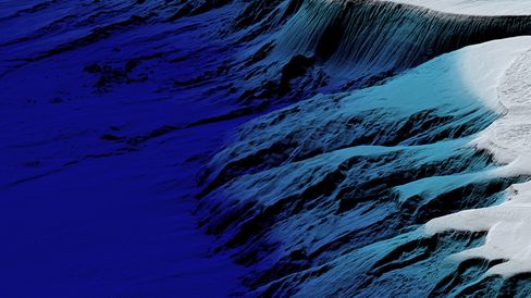 Landscape with snow-covered and shadowed mountain slopes under a blue sky