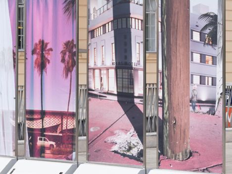 Several upright rectangular panels displaying photographs of palm trees and flooded urban streets