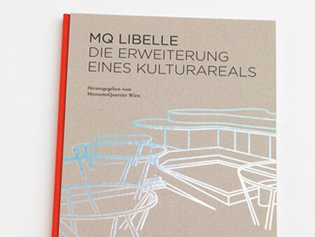 Buch mit beigem Umschlag und rotem Buchrücken, Titel 'MQ Libelle Die Erweiterung eines Kulturareals', silberne Linienzeichnung von Tischen und Stühlen auf dem Umschlag