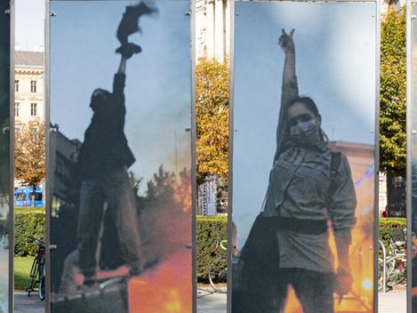 A row of vertical photo panels showing masked protesters raising fists amid smoke in a city plaza.