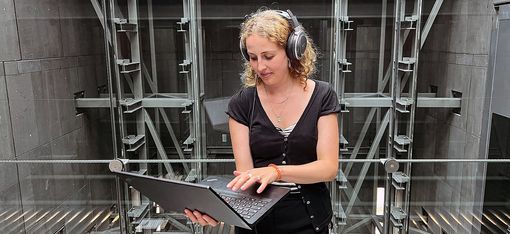 Frau mit Laptop und Kopfhörern