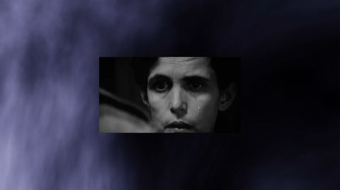 Nahaufnahme eines nachdenklichen Gesichts einer Person vor dunklem Hintergrund