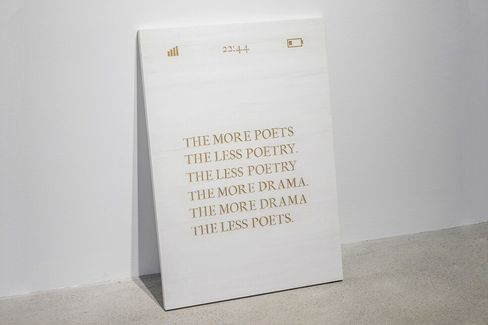 White poster with gold uppercase text reading "THE MORE POETS THE LESS POETRY THE LESS POETRY THE MORE DRAMA THE MORE DRAMA THE LESS POETS" with small icons for signal, time "22:44", and battery at the top.