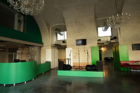 A raised platform in the foyer of DSCHUNGEL WIEN, featuring a green cloakroom and ticket office