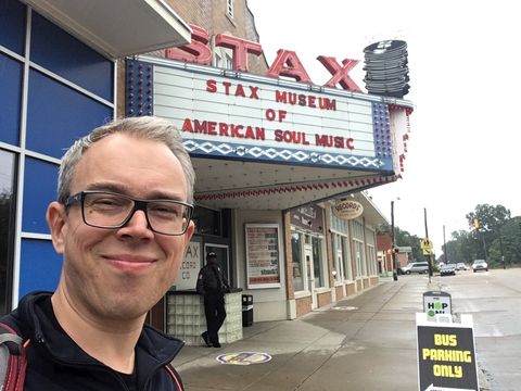 Person with blurred face in front of the Stax Museum of American Soul Music with distinctive marquee and street view.