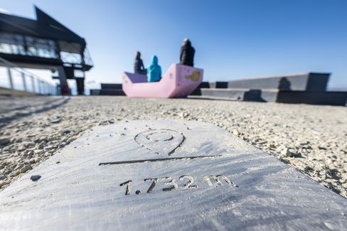 Pink Enzi on the viewing terrace of Mount Schafberg with visitors seated in the background.