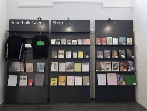 Books and merchandise wall in the Kunsthalle Wien shop displaying exhibition catalogues, art publications and textiles at MuseumsQuartier Vienna.