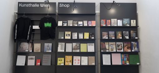 Books and merchandise wall in the Kunsthalle Wien shop displaying exhibition catalogues, art publications and textiles at MuseumsQuartier Vienna.