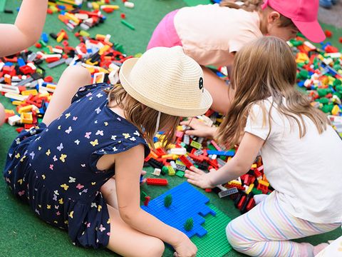 Children are sitting in a big pile of Legos.