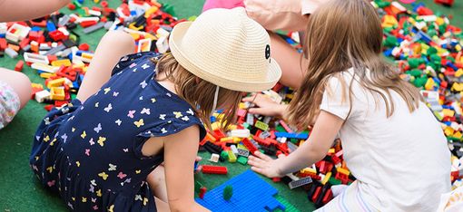 Children are sitting in a big pile of Legos.