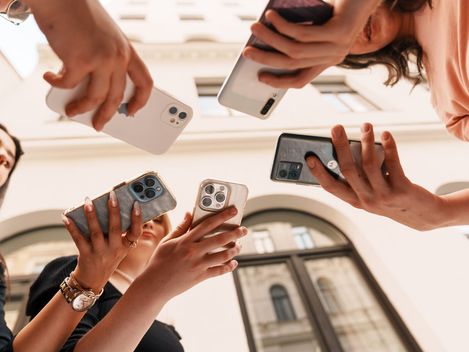 5 hands hold 5 phones