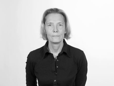 Woman with shoulder-length hair wearing a black shirt against a white background