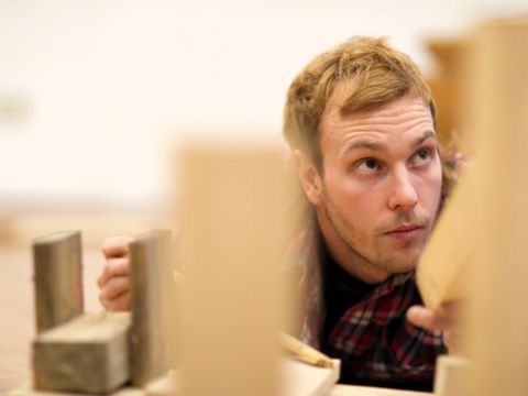 A person is trying to assemble individual components. With varying degrees of success.