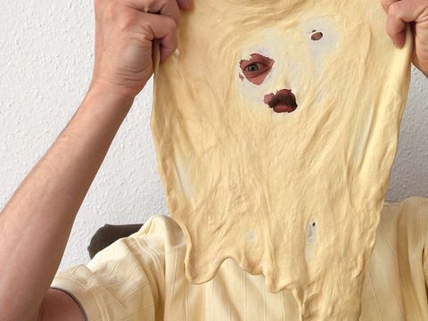 A person is looking through a hole in a piece of dough.