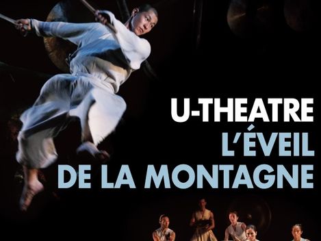 Dancer in white clothing leaps above a group of five drummers in traditional attire against a black background with the text "U-THEATRE L'ÉVEIL DE LA MONTAGNE".